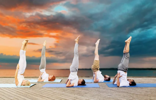 매트에 shoulderstand 포즈에서 요가 만드는 사람들 — 스톡 사진