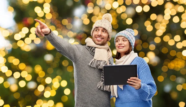 Couple with tablet computer over christmas lights — Stock Photo, Image