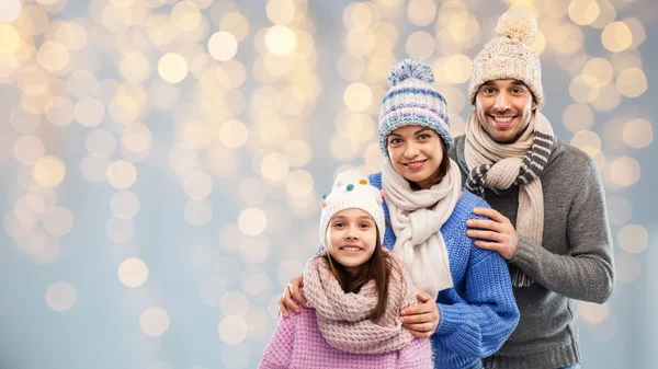 Familie i vintertøj over julelys - Stock-foto
