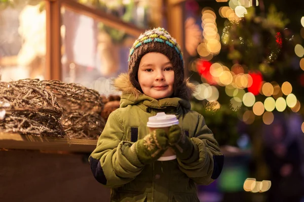 Szczęśliwy chłopiec z filiżanką herbaty na targu bożonarodzeniowy — Zdjęcie stockowe