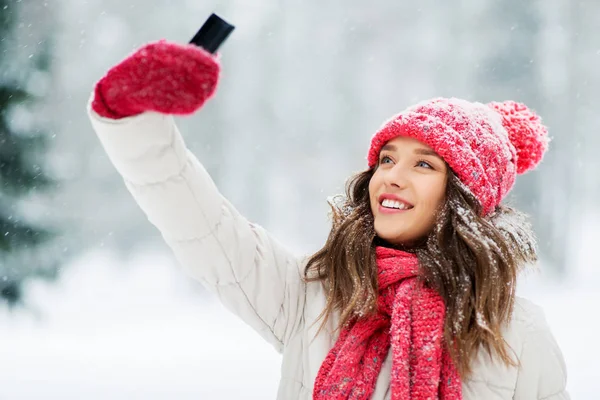 冬にスマートフォンで自分撮りをする若い女性 — ストック写真