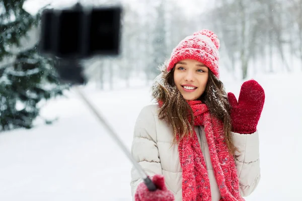 Jovem mulher tomando selfie por monopod no inverno — Fotografia de Stock
