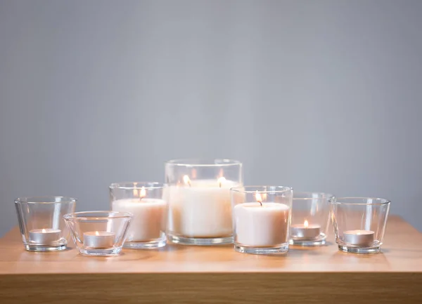 Bougies parfumées blanches allumées sur une table en bois — Photo