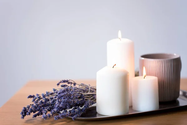 Svíčky, čaj v džbánku a levandulové květy na stole — Stock fotografie