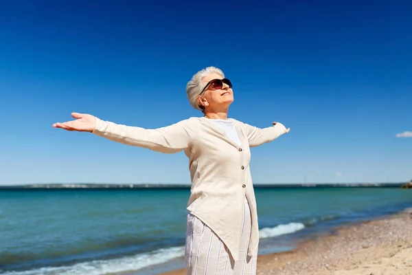 Retrato de mujer mayor en gafas de sol en la playa —  Fotos de Stock