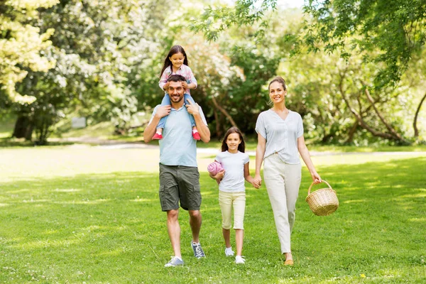 Familie met picknickmand wandelen in zomerpark — Stockfoto