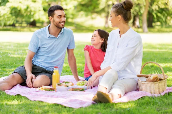 Familia feliz teniendo un picnic en el parque de verano — Foto de Stock