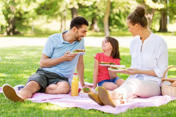 Szczęśliwa rodzina o piknik w parku letnim — Zdjęcie stockowe
