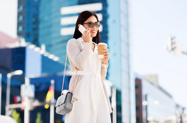 Mosolyogva ázsiai nő, amelyben a smartphone a városban — Stock Fotó