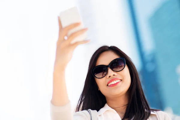 Asian woman taking selfie by smartphone in city — Stock Photo, Image