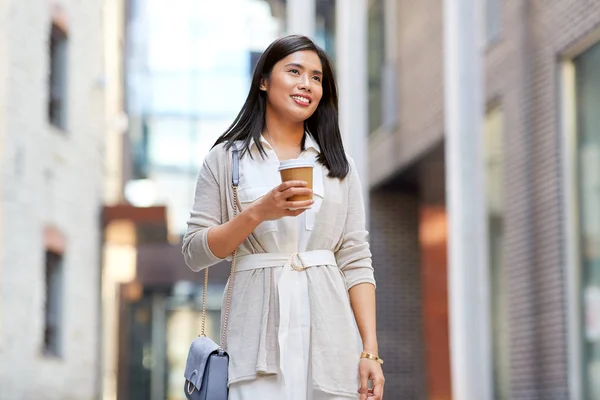 市内でテイクアウトコーヒーカップを持つ笑顔の女性 — ストック写真