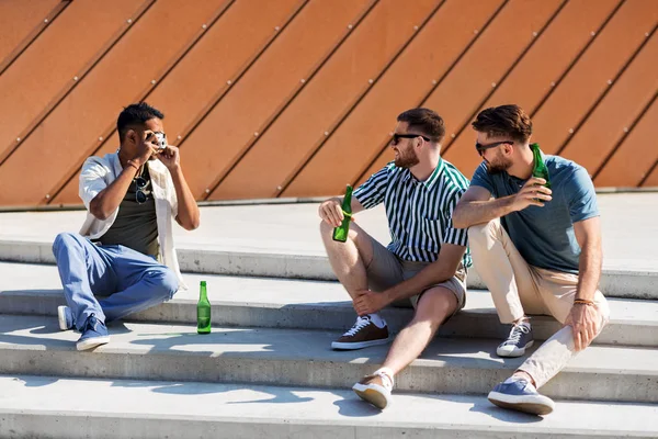 Hombre fotografiando amigos bebiendo cerveza en la calle — Foto de Stock