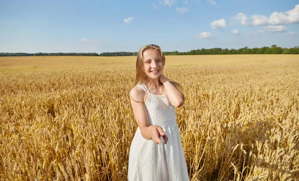 Gelukkig meisje nemen selfie op graanveld — Stockfoto