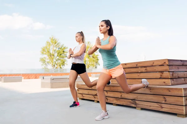 Mujeres entrenando y haciendo sentadillas divididas — Foto de Stock