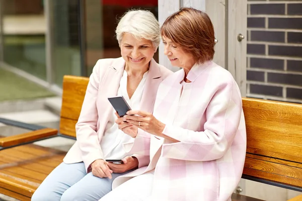 Boldog idős nők okostelefonok a város — Stock Fotó