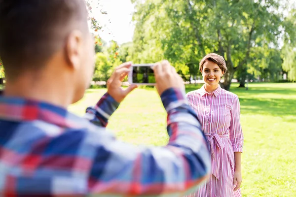 Pareja fotografiando por smartphone en parque —  Fotos de Stock