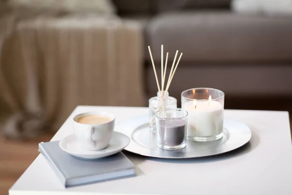 Café, velas y difusor de caña de aroma en la mesa —  Fotos de Stock
