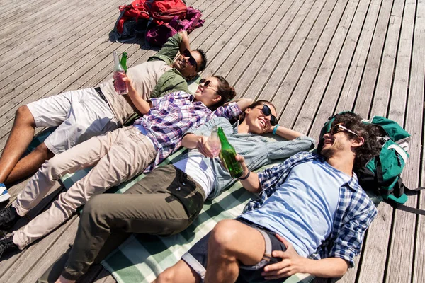 Friends drinking beer and cider on wooden terrace — Stock Photo, Image