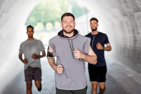 Männliche Freunde mit Kopfhörern im Freien — Stockfoto