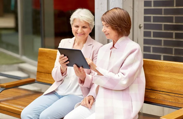 Пожилые женщины с планшетным компьютером в городе — стоковое фото