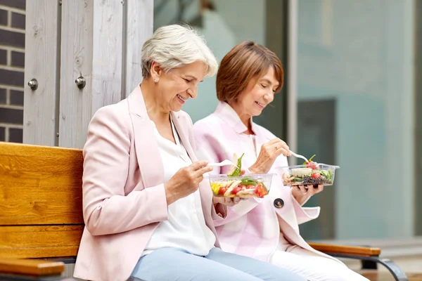 Senior vrouwen eten afhaalmaaltijden op City Street — Stockfoto