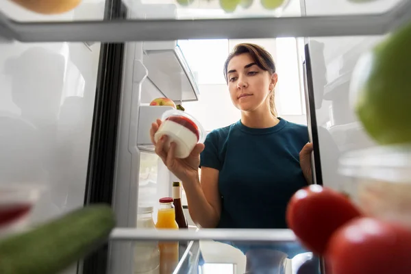 Femme prenant de la nourriture du réfrigérateur à la maison — Photo