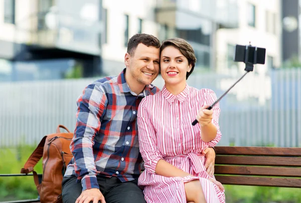 Family couple with stroller taking selfie in city — Zdjęcie stockowe