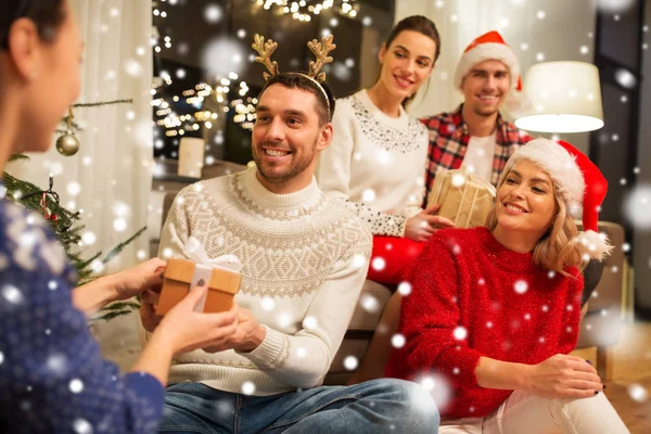 Amigos celebrando o Natal e dando presentes — Fotografia de Stock