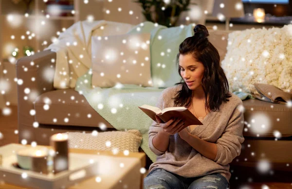 Счастливая молодая женщина читает книгу дома — стоковое фото