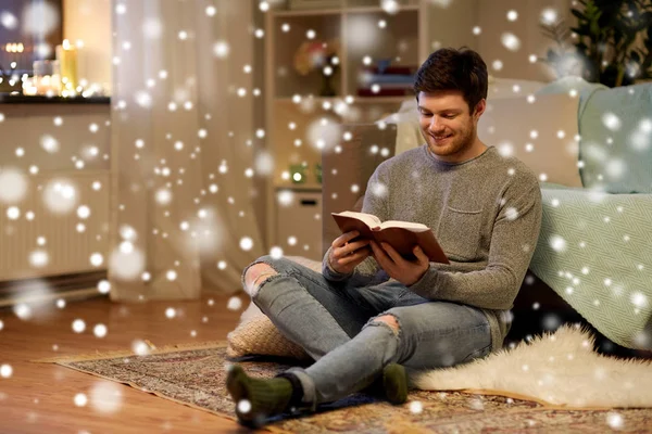 Szczęśliwy młody człowiek, czytanie książki w domu — Zdjęcie stockowe