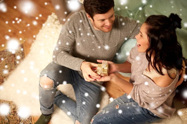 Feliz pareja con caja de regalo en casa — Foto de Stock