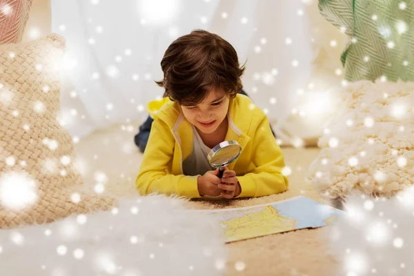 Niño con lupa y mapa en tienda de campaña para niños en casa —  Fotos de Stock