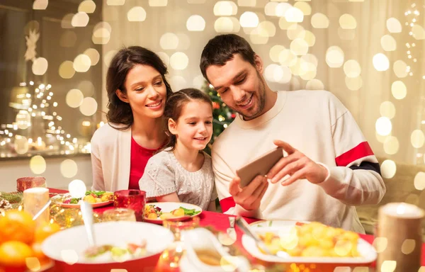 Family with smartphone having christmas dinner — Stock Photo, Image