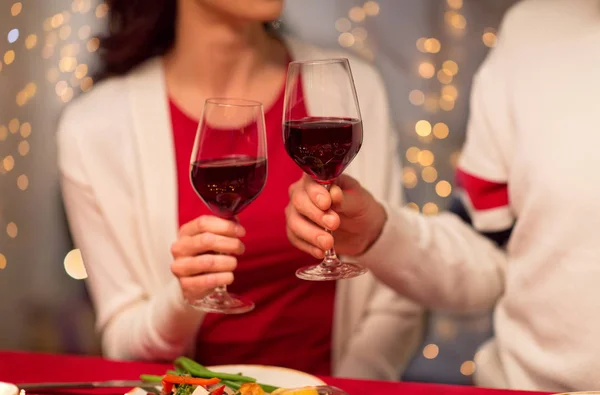 Κοντινό πλάνο ζευγάρι πόσιμο κόκκινο κρασί για τα Χριστούγεννα — Φωτογραφία Αρχείου