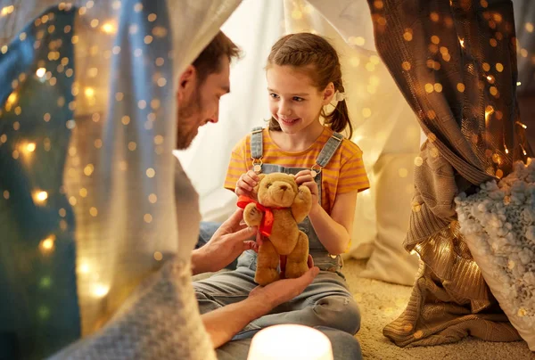 Famiglia felice che gioca con il giocattolo nella tenda dei bambini a casa — Foto Stock