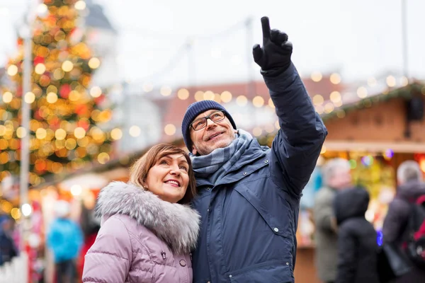 Heureux couple de personnes âgées étreignant au marché de Noël — Photo