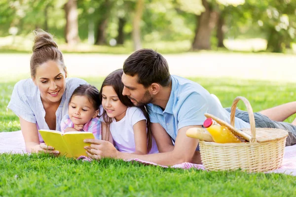 Livro de leitura da família em piquenique no parque de verão — Fotografia de Stock