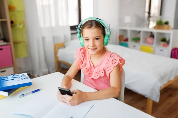 Lány fejhallgató hallgat zenét mobiltelefon — Stock Fotó