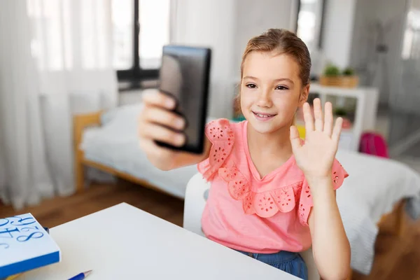 スマートフォンを手にした幸せな女の子が自宅で — ストック写真