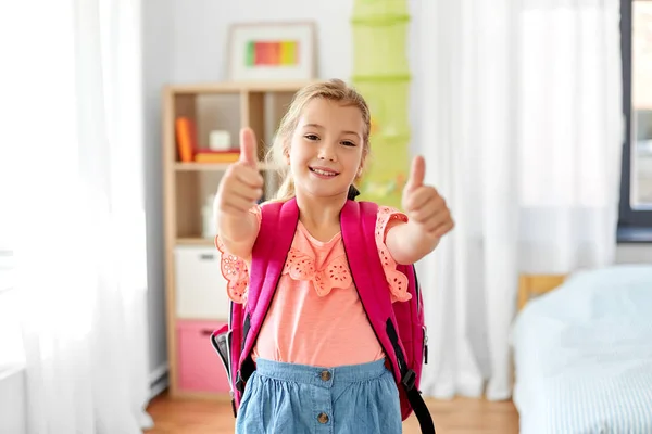 Estudiante chica con la escuela bolsa mostrando pulgares hacia arriba — Foto de Stock