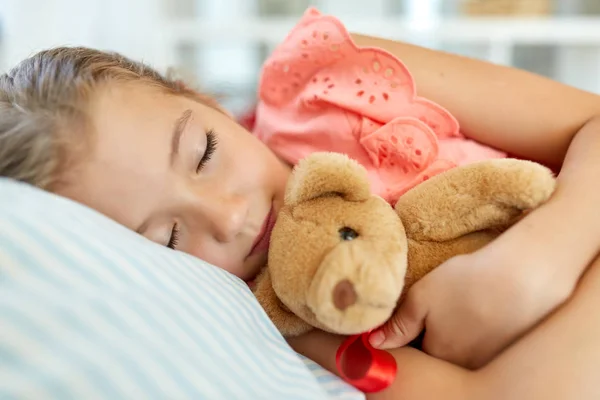 Kleines Mädchen schläft mit Teddybär-Spielzeug zu Hause — Stockfoto