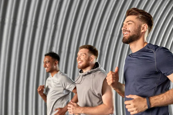 Young men or male friends running outdoors — Stock Photo, Image