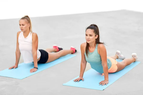 Femmes faisant du sport sur des tapis d'exercice à l'extérieur — Photo