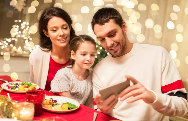 Familia con smartphone teniendo cena de Navidad — Foto de Stock