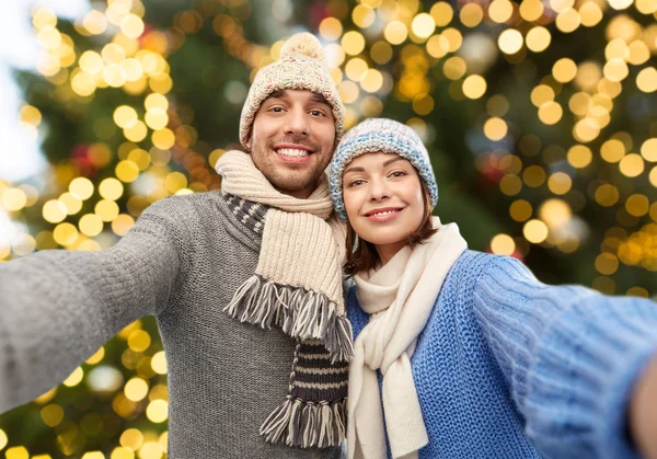 Feliz pareja tomando selfie sobre navidad luces —  Fotos de Stock