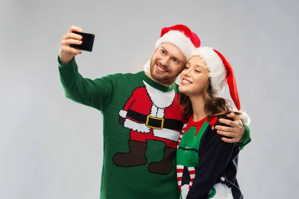 Felice coppia in maglioni di Natale prendendo selfie — Foto Stock