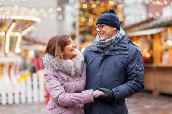 Heureux couple de personnes âgées étreignant au marché de Noël — Photo