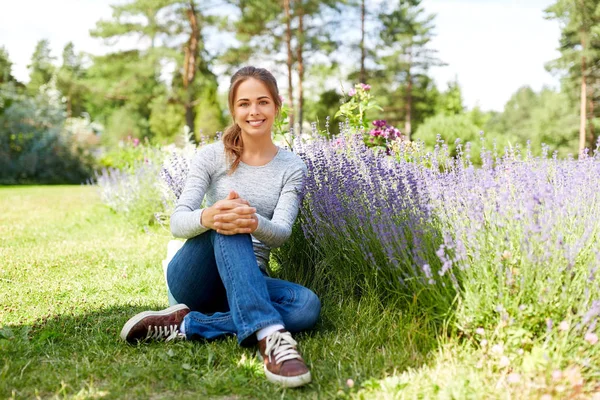Young woman and lavender flowers at summer garden — Stock Photo, Image