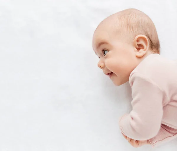 Doce bebê menina deitado no branco cobertor — Fotografia de Stock