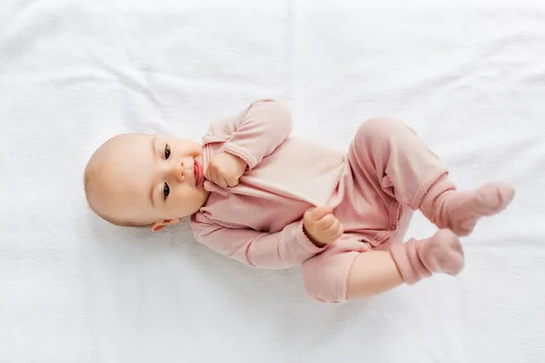 Doce bebê menina deitado no branco cobertor — Fotografia de Stock